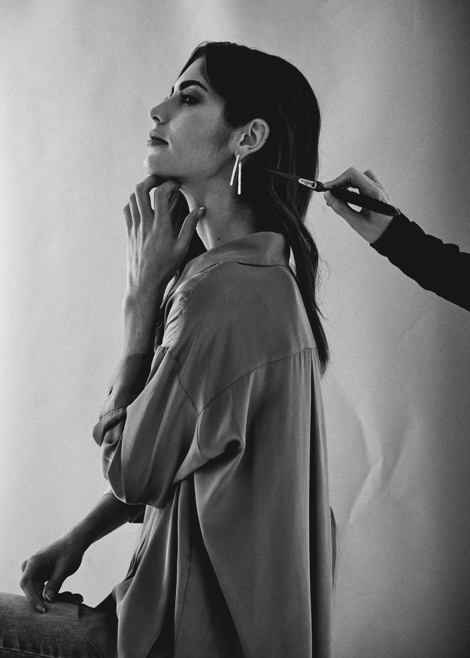 Retoque de maquillaje en el set de una sesión de joyas, en blanco y negro
