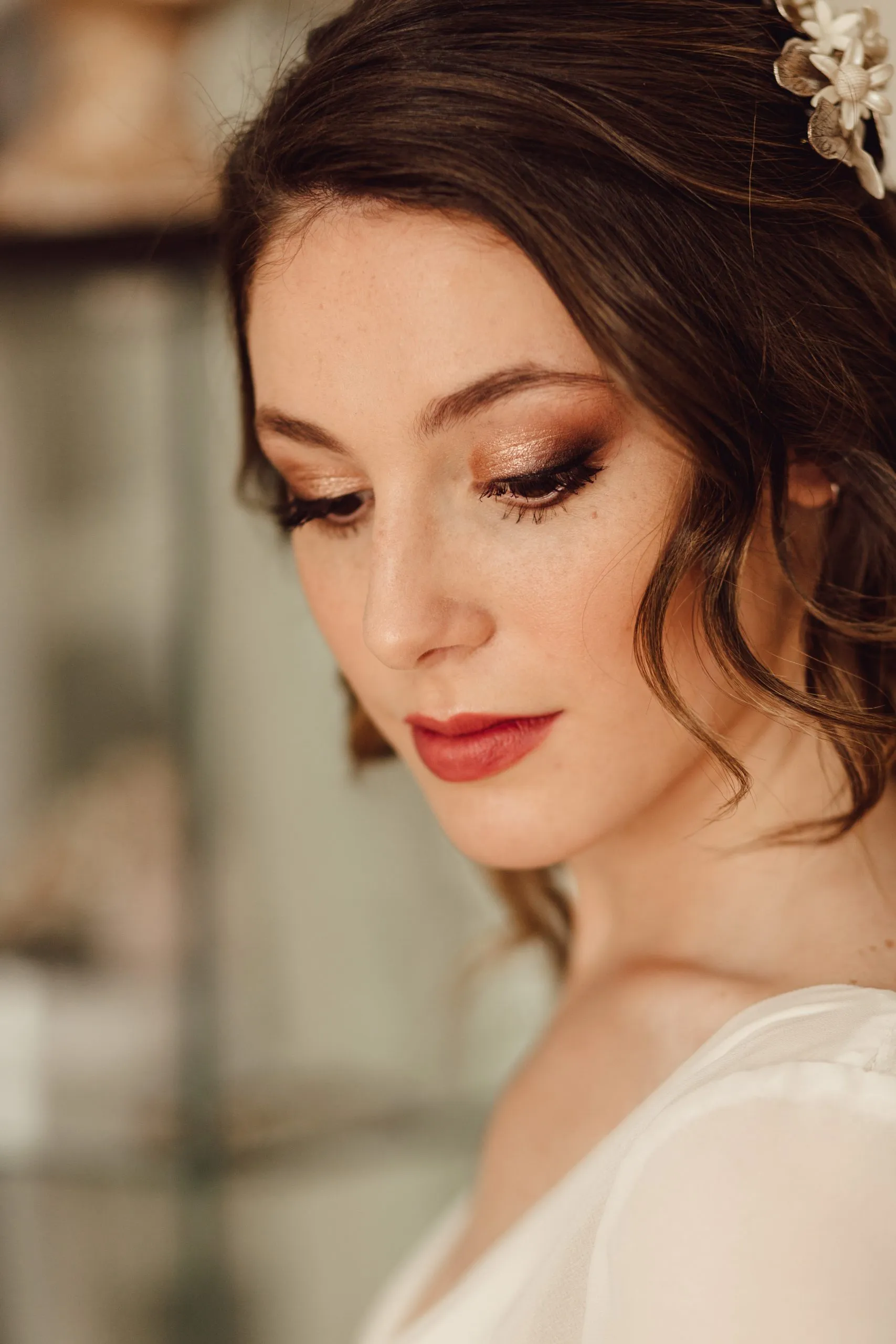 Novia con maquillaje en tonos cálidos y tocado de flores, maquillada y peinada por Anartist