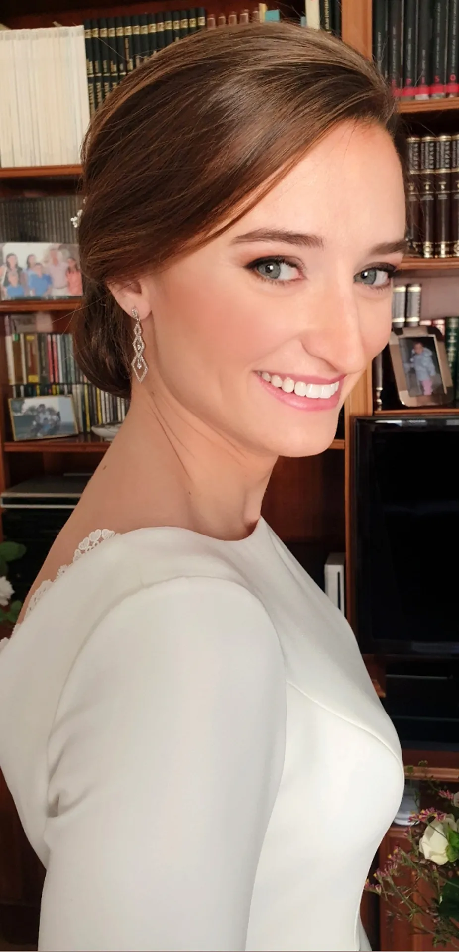 Novia sonriendo con recogido y pendientes largos